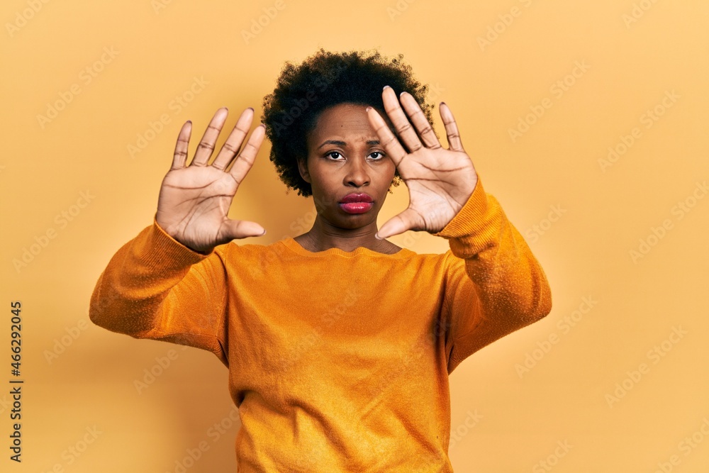 Young african american woman wearing casual clothes doing frame using hands palms and fingers, camera perspective