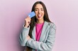 © Krakenimages.com - Young hispanic girl holding credit card sticking tongue out happy with funny expression.