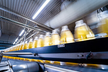 Wall Mural - Conveyor belt with bottles for juice or water at a modern beverage plant