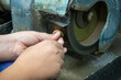 A Child Grinding and Forming a Gemstone Using a Rock Grinder in a Lapidary Shop to form a Stone