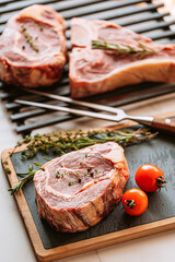 Wall Mural - three delicious steaks ready to grill on a white marble surface