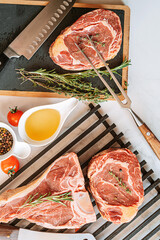 Wall Mural - three delicious steaks ready to grill on a white marble surface