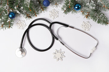 Wall Mural - Celebrating Christmas in the healthcare industry. Stethoscope with ornaments and snowflakes on white background