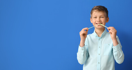 Wall Mural - Cute little boy chewing gum on blue background