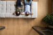 © fizkes - Serene couple put hands behind head relaxing on cozy sofa, above view. Homeowners family enjoy rest on fashionable furniture, breathing fresh conditioned air inside modern living room. Tenant concept