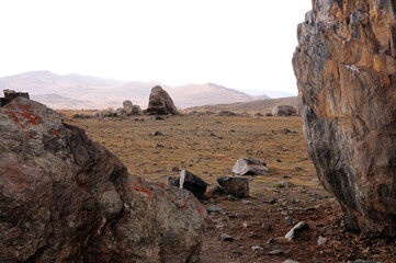 Remains of an ancient stone observatory standing in the center of the steppe in early autumn.