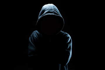 computer hacker in black mask and hoodie. obscured dark face. data thief, internet fraud, cyber secu