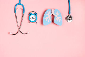 Wall Mural - Prevention of pulmonary disease. Lung symbol, stethoscope and alarm clock on a pink background.