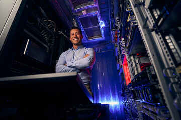 Happy IT technician standing in server room