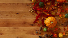 Thanksgiving Background With Fall Leaves, Gourds And Pine Cones On A Natural Wood Tabletop.