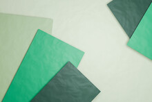 Three Dimensional Render Of Green Sheets Of Paper Against Pastel Green Background