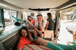 © Westend61 - Woman with hand on chin sitting with female friends in motor home