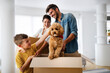 © NDABCREATIVITY - Husband and wife and their son with pet moving in new home.