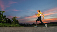 Young Woman Jogging Alone At Dusk