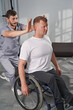 Physiotherapist check joint flexibility of wheelchair man in rehab gym