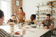© Seventyfour - Warm toned portrait of diverse group of people decorating ceramics in pottery workshop, copy space