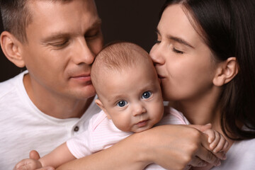 Wall Mural - Happy family with little baby on dark background