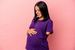Young pregnant woman with one arm isolated on pink background