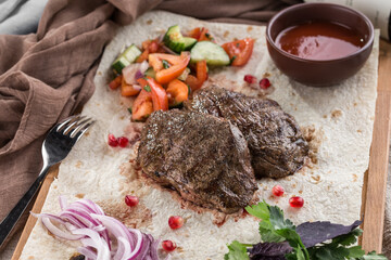 Wall Mural - grilled fillet steak with fresh vegetables, flat bread and tomato sauce on the table