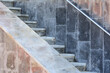 marble steps run along the wall with a metal rail