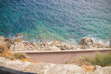 Sticker - Top view of the sea with clean blue water and rocky coast with short walls