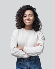 Beautiful young business woman with crossed arms studio portrait. Smiling student girl looking at camera isolated on gray background. People concept	