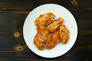 Wall Mural - Raw chicken in white plate on wooden table.