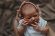 © Ananass - close up portrait of a beautiful baby in the arms of mom in the bedroom in daylight