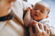 © Ananass - close up portrait of a beautiful sleeping baby in the arms of mom in the bedroom in daylight