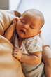 © Ananass - close up portrait of a beautiful sleeping baby in the arms of mom in the bedroom in daylight