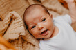 © Ananass - close up portrait of a little child on the bed in her room. Cute baby lies on blanket.