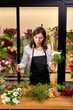 Young Female professional florist prepares the arrangement of wild flowers. Cute caucasian lady in apron making bouquet. Flower shop. inspiration, floral, greetings, spring, ornament flowers