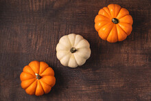 Top View Of Mini Pumpkins On Wooden Background. Autumn And Halloween Concept