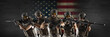Professional special forces soldiers, during a special operation against a dark concrete wall and US flag background. They are defending flag. Photo format 3x1.