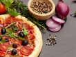 Italienische Pizza und Zutaten und Gewürze zum Kochen , Tomaten, Pfeffer, Salz, Rosmarin, Kräutern und lebendig auf schwarzem Hintergrund.