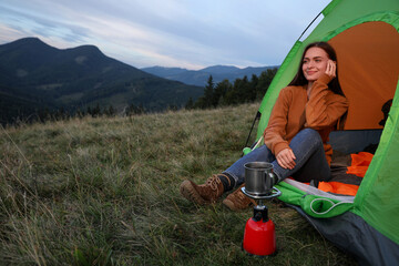 Poster - Young woman enjoying mountain landscape in camping tent