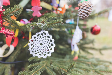 DIY white doily on Christmas tree. Handmade Christmas decoration ideas for children. Environment, reuse, recycle, upcycling and zero waste concept. Selective focus, copy space