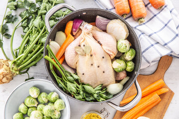 Wall Mural - Chicken ready to cook broth with fresh root vegetables and spices