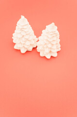 Poster - white decorative wax fir trees on a salmon pink background with