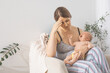 © oksix - The young mom wants to breastfeed her newborn baby