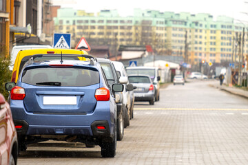 Canvas Print - Cars parked in a row on a city street side.