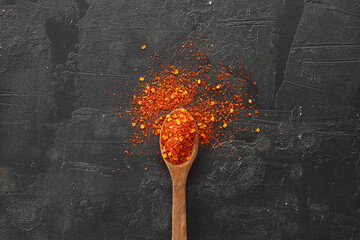 cayenne pepper on wooden spoon spices and dried chilli peppers background / group of red hot chilli powder on black plate top view ingredients table asian food spicy in thailand