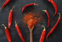 Cayenne Pepper On Wooden Spoon Spices And Dried Chilli Peppers Background / Group Of Red Hot Chilli Powder On Black Plate Top View Ingredients Table Asian Food Spicy In Thailand