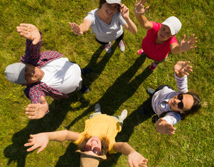 Canvas Print - Top aerial view of happy people standing in circle on green grass. Drone photography