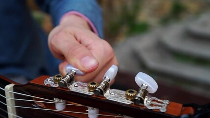 Poster - A closeup shot of a musician setting up the guitar strings