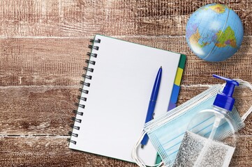 Poster - Medical and healthcare concept. Facemask, hand sanitizer, earth globe and paper on the desk