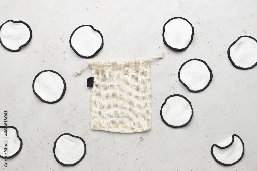 Reusable cotton pads and bag on light background