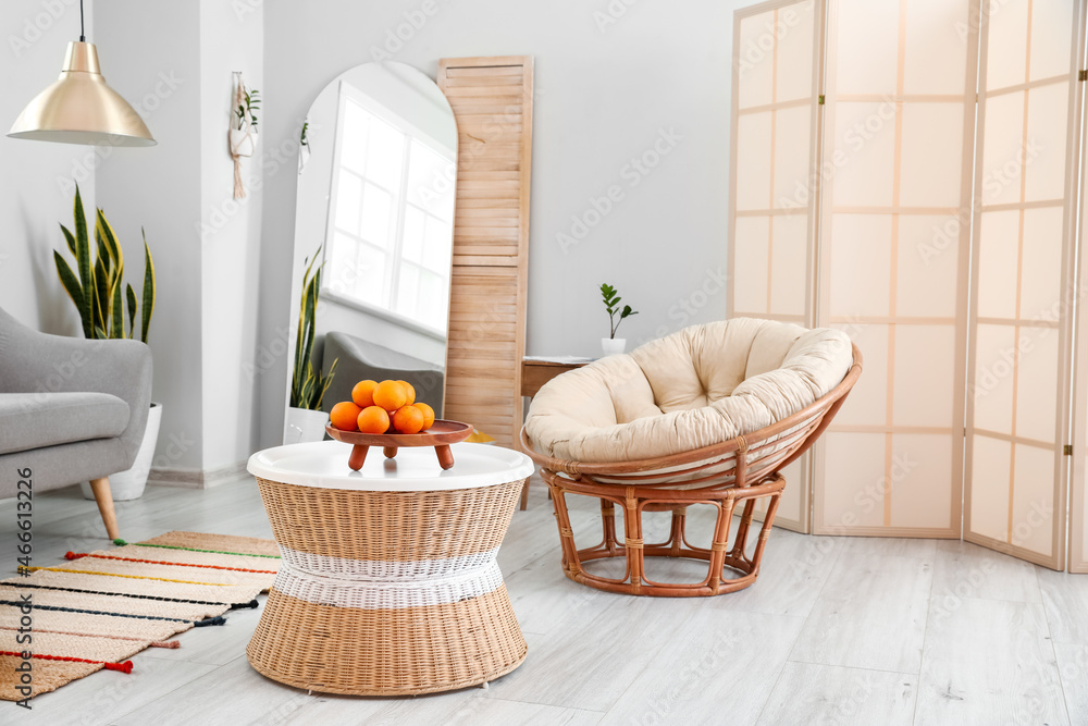 Modern living room interior with stylish mirror, table and armchair