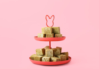 Wall Mural - Stand with tasty hojicha marshmallows on pink background