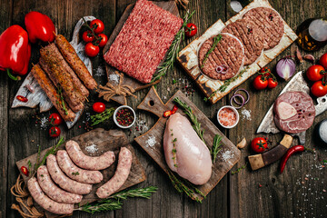 Wall Mural - Various kinds of grill and bbq raw meats. Chicken, steak, sausages, minced beef meat kebabs, pork with herbs, spices on wooden background. top view